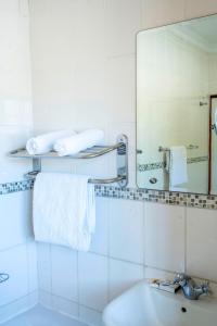a white bathroom with a sink and a mirror at Kang Juliet Hotel in Kang