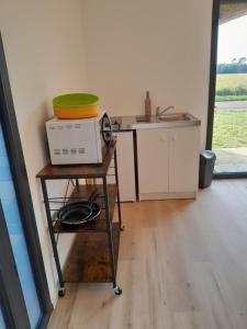 a microwave sitting on a table in a kitchen at Appartement dans grange rénovée in Meilhan