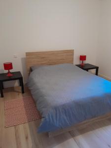 a bedroom with a bed with two red lamps on two tables at Appartement dans grange rénovée in Meilhan