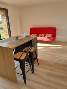 a room with a table and chairs and a red couch at Appartement dans grange rénovée in Meilhan
