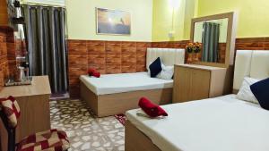 a room with two beds with red shoes on them at Hotel Raj in Siliguri
