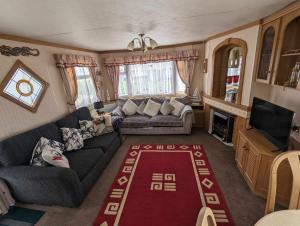 a living room with a couch and a television at seaside holiday in Ingoldmells