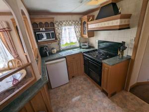 a small kitchen with a stove and a sink at seaside holiday in Ingoldmells