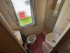 a small bathroom with a toilet and a sink at seaside holiday in Ingoldmells