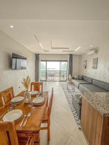 a dining room with a table and a couch at Appartement Luxe OMiramar Balcon Privé Vue in Agadir +14 photos