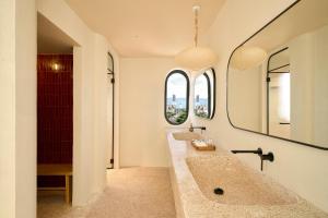 two sinks in a bathroom with two mirrors at Hotel Chavana Da Nang in Danang