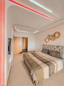 a bedroom with a large bed and a tv at Appartement Luxe OMiramar Balcon Privé Vue in Agadir