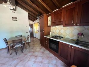 a kitchen with wooden cabinets and a table with a sink at Agriturismo Le Roncacce in Abetone