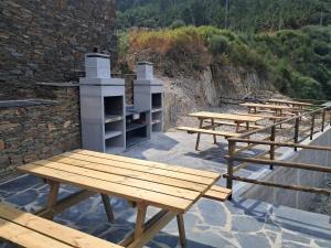 a row of picnic tables sitting next to a building at AL Rossadas Giesta in Arganil