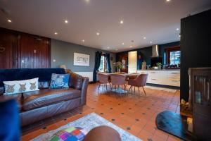 a living room with a leather couch and a table at The Cottage at Barraston Farm in Balmore