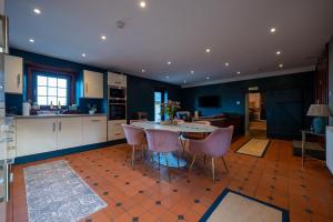 a kitchen with a table and chairs in a room at The Cottage at Barraston Farm in Balmore
