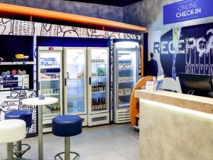 a store with two refrigerators and a counter and chairs at ibis budget Osasco in Osasco