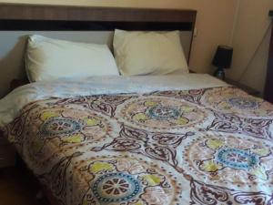 ein Bett mit einer bunten Decke darauf in der Unterkunft Costa cab in Martil
