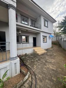 a white house with a porch and a balcony at Barry's Hilton extension in Abuja +48 photos