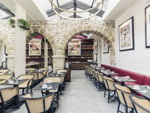 a restaurant with tables and chairs and a brick wall at Hôtel Mercure Bayonne Centre Le Grand Hotel in Bayonne