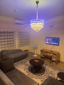 a living room with a chandelier and a couch and a table at Barry's Hilton extension in Abuja