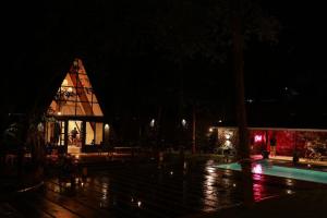 a lit up building with a pool at night at Outhouse by Thottupuram in Muttam