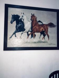 a painting of horses running in the snow at T N D House in Habaraduwa Central