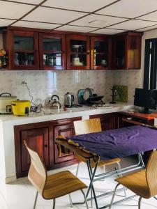 a kitchen with wooden cabinets and a table and chairs at T N D House in Habaraduwa Central