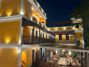 a building with a balcony with tables and chairs at Hotel Grand Palais in Bangalore