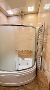 a bathroom with a tub in the middle of a room at Stylish Stay Overlooking Fountain Square in Baku