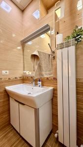 a bathroom with a white sink and a mirror at Stylish Stay Overlooking Fountain Square in Baku