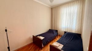 a bedroom with two beds and a chair in it at Stylish Stay Overlooking Fountain Square in Baku