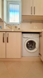 a kitchen with a washing machine and a window at Stylish Stay Overlooking Fountain Square in Baku
