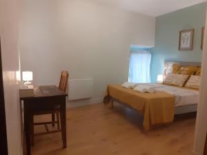 a bedroom with a bed and a desk and a table at Lagnieu in Lagnieu