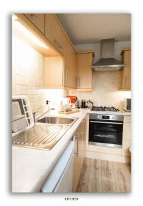 a kitchen with a sink and a stove at Clarefoot Cottage in Moffat