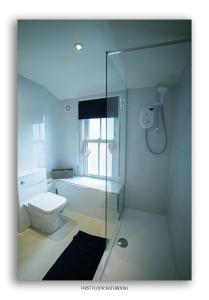 a bathroom with a glass shower and a toilet at Clarefoot Cottage in Moffat