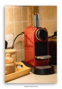 a red coffee maker sitting on top of a counter at Clarefoot Cottage in Moffat