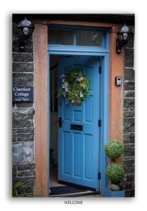 a blue door with a plant on top of it at Clarefoot Cottage in Moffat