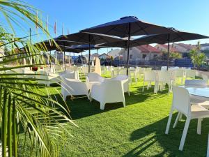 a group of tables and chairs with an umbrella at Harpazul in Catoira