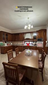 una cucina con tavolo, sedie e lampadario pendente di Valendriu's House a Torre Annunziata