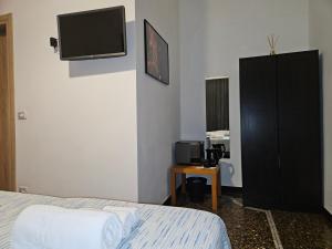 a bedroom with a bed and a tv on the wall at Affittacamere House LeoMar di Sara in Genova