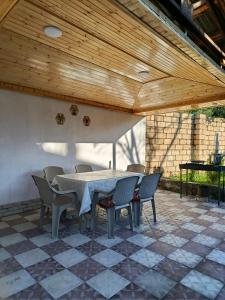 a table and chairs on a patio with a wooden ceiling at Villa Gabala in Gabala