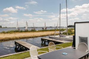a table and chairs next to a marina with boats at Herenhuis geschakeld | 6 personen - Boutique Parc Pharshoeke in Heeg +40 photos