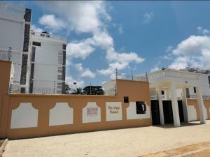 a building with two tall buildings in the background at Da Azizi Homes Diani- Lior in Kwale