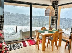 Un comedor con una mesa y un gran ventanal. en Domek Tatry - Stacja Wierchowa 972 m, en Brzegi