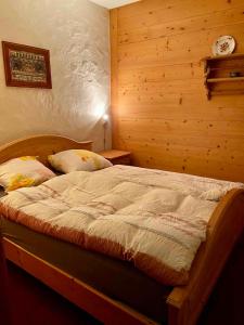 a bedroom with a bed with a wooden wall at Parterre-Wohnung im Zentrum in Gstaad