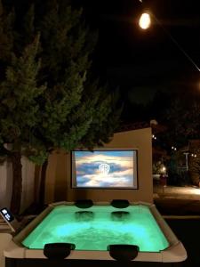 a pool with a tv in a backyard at night at Daydream Nature Home - Hot Tub & Cinema Experience in Oinóï
