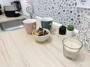 a counter top with two cups and a bowl of food at Pécs Király 12 in Pécs +13 photos