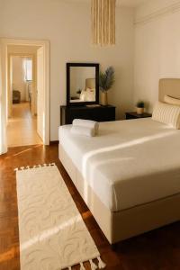 a bedroom with a large white bed and a mirror at Daydream Nature Home - Hot Tub & Cinema Experience in Oinóï