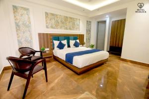 a bedroom with a bed and a chair in it at Hotel Wedlock in Gurgaon +28 photos