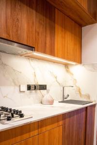 a kitchen with wooden cabinets and a stove top oven at House B thonningii - warm minimalism in Nanyuki