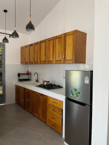 a kitchen with wooden cabinets and a stainless steel refrigerator at Kezzy homes in Mombasa