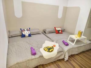 a bedroom with a large bed with purple pillows at SQ31 Sq where 55 inch 4 ktv sungai buloh in Shah Alam