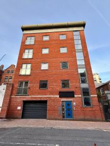 a red brick building with a blue door at Bloom Apartments - City Centre - Gated Parking in Manchester