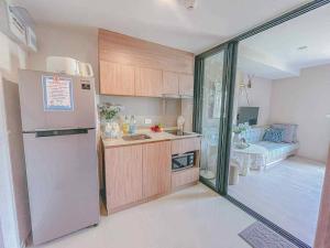 a small kitchen with a refrigerator and a room at Exclusive Apartment with Pool - Self Check In in Hua Hin